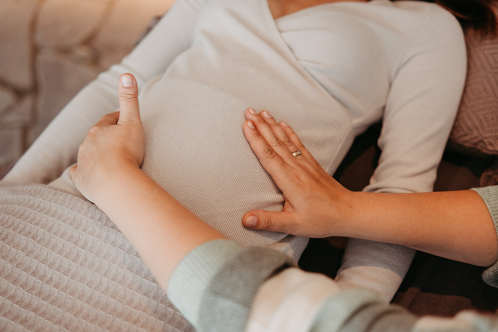 Hände ruhen auf dem Bauch einer Schwangeren